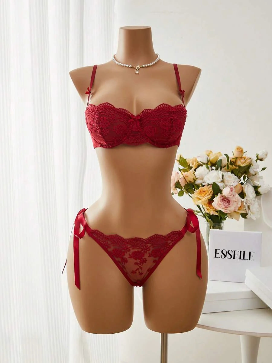 Conjunto de lencería de encaje rojo burdeos con lazos en un maniquí.