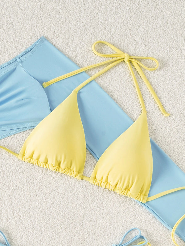 Detalle del top celeste de hombros descubiertos con fruncido y cuello halter amarillo