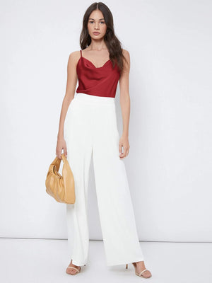 Combinación de la blusa burdeos con pantalones blancos para un estilo elegante y moderno.