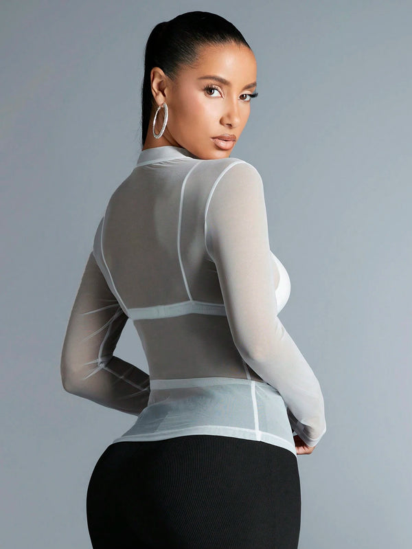 Mujer luciendo top blanco de malla transparente de espaldas.