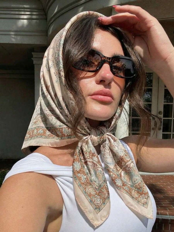 Primer plano del pañuelo estampado paisley y geométrico atado en el cabello de una mujer.