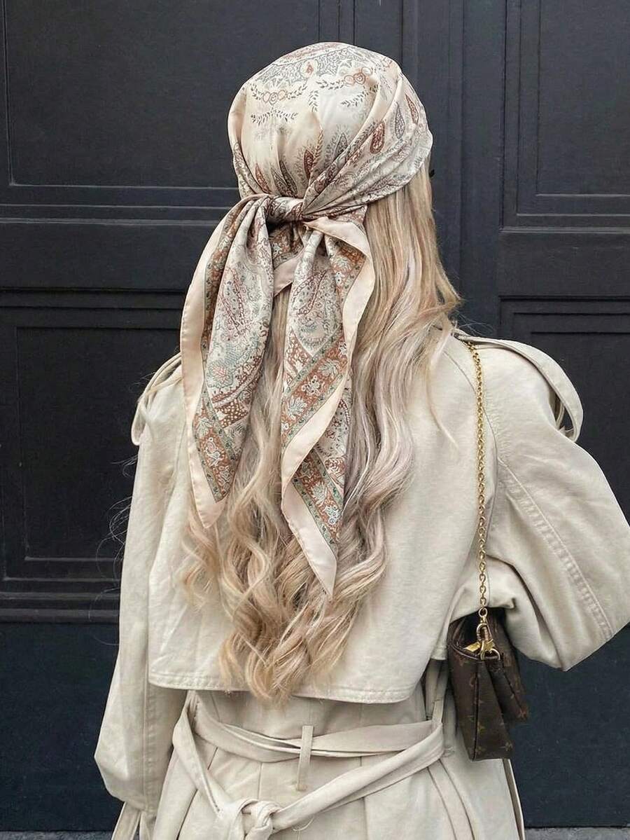 Vista trasera de una mujer con cabello rubio usando un pañuelo estampado en tonos beige atado en la cabeza.