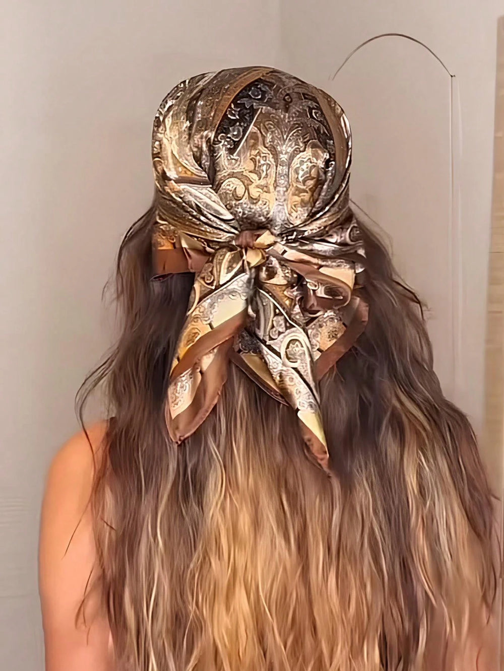 Pañuelo de cabello bohemio paisley café usado como accesorio en la playa