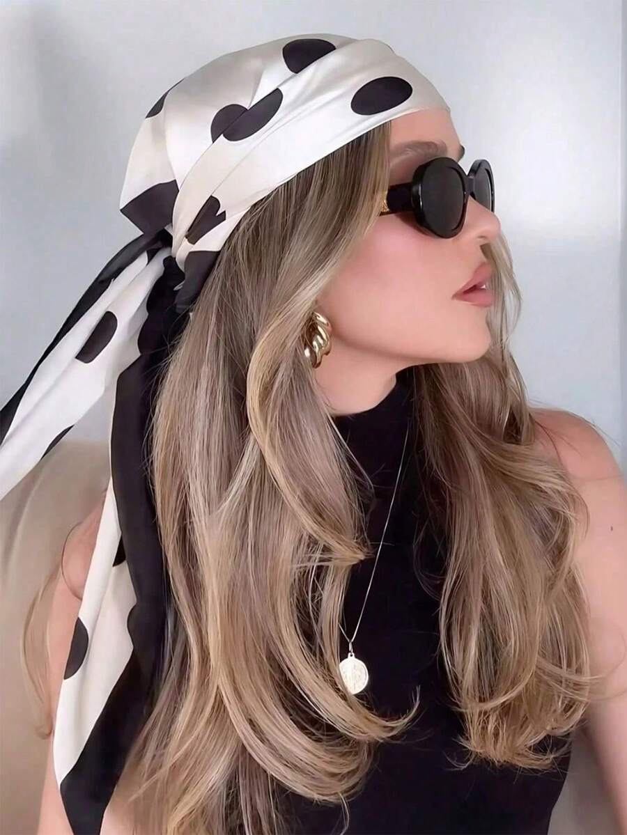 Mujer de perfil usando un pañuelo de lunares blanco y negro en la cabeza y gafas de sol.