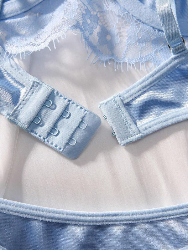 Parte trasera de la tanga azul de satín y encaje junto a un frasco de perfume.