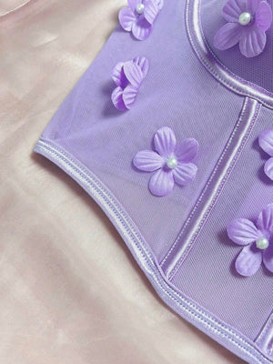 Modelo junto a la ventana, luciendo el top romántico floral Lila con apliques.