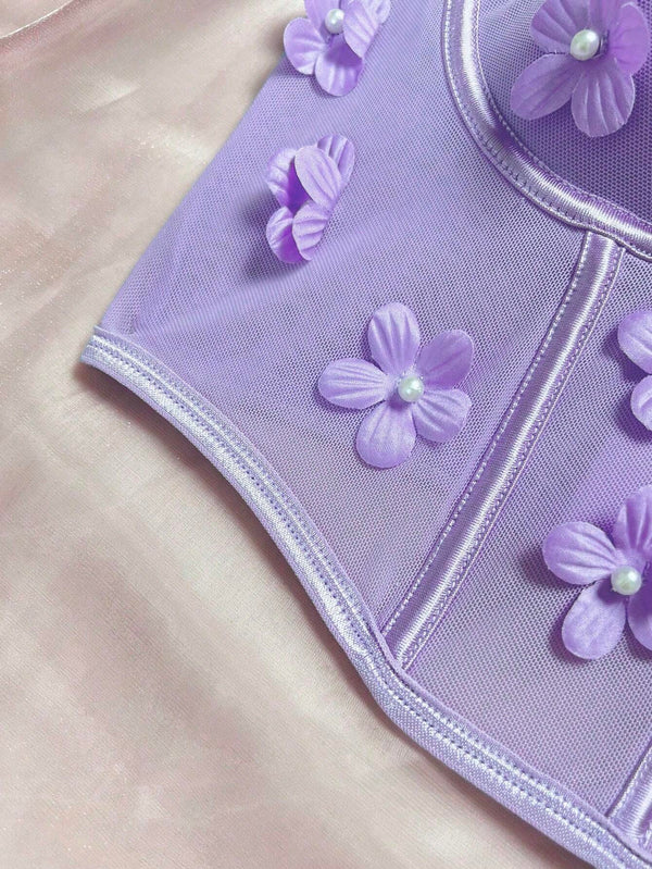 Modelo junto a la ventana, luciendo el top romántico floral Lila con apliques.