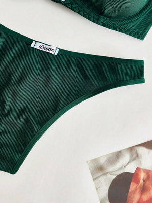 Detalle de la tanga de lencería verde oscuro con textura acanalada.