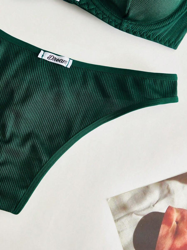 Detalle de la tanga de lencería verde oscuro con textura acanalada.