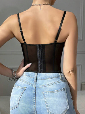 Vista de cerca del torso luciendo un top corset de encaje negro combinado con jeans de talle alto.