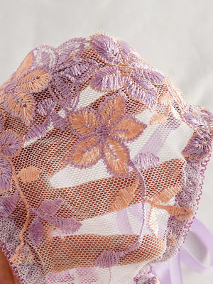 Textura bordada floral en tonos lila y durazno del set morado.