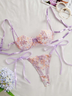 Vista frontal del set de lencería morado con bordado floral y lazos.