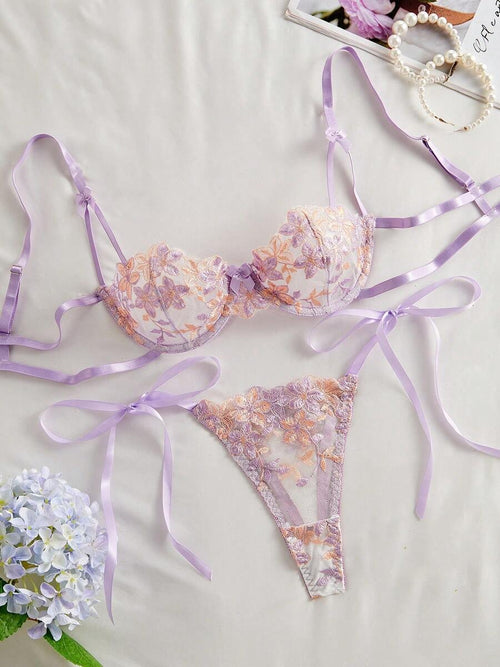 Vista frontal del set de lencería morado con bordado floral y lazos.
