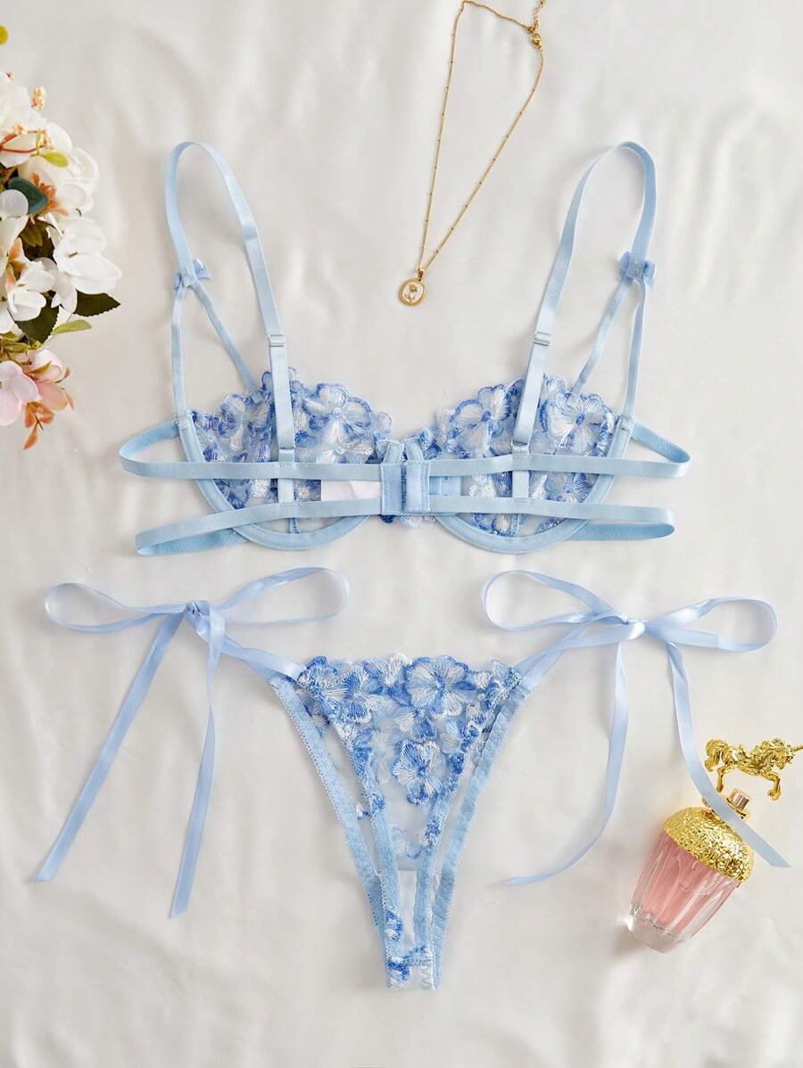 Set de lencería azul con encaje floral y lazos decorativos