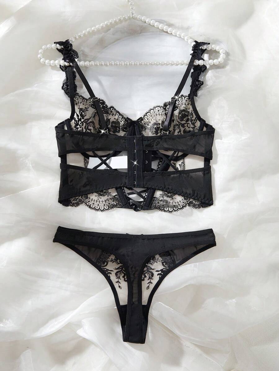 Conjunto de lencería de dos piezas estilo corset en negro y beige con bordado floral.