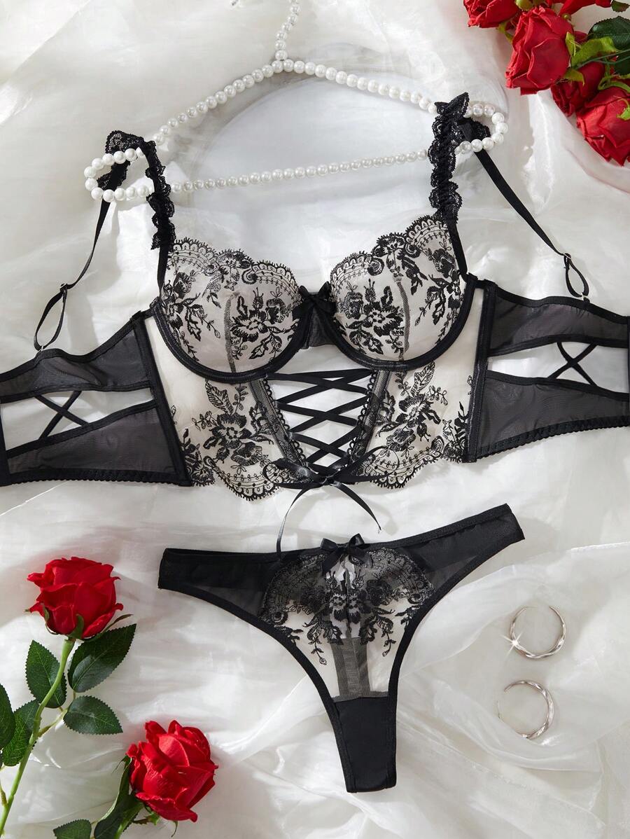 Conjunto de lencería de dos piezas estilo corset en negro y beige con bordado floral.