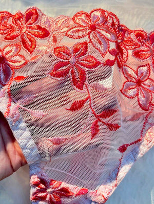 Vista detallada de la panty tipo tanga con bordado de flores rojas y rosas, a juego con el sujetador.