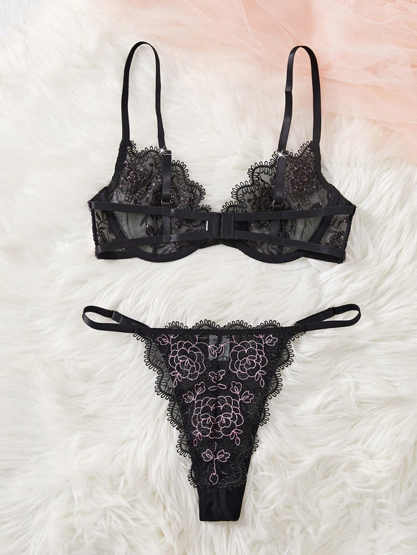 Conjunto de lencería negra bordada con tanga vista posterior
