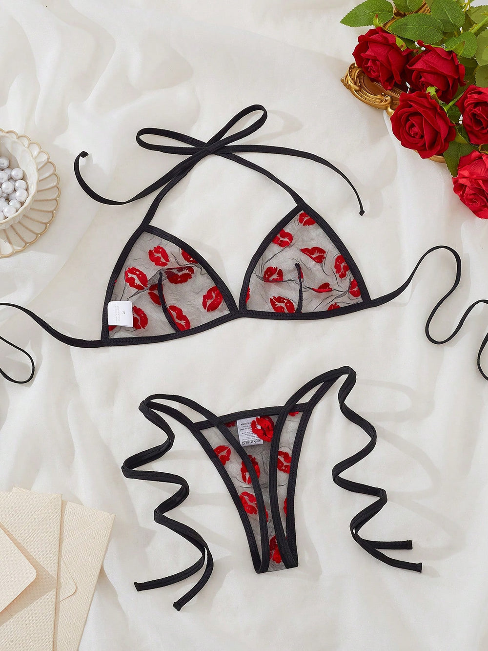 Conjunto de lencería negro transparente con estampado de labios romántico floral vista completa.
