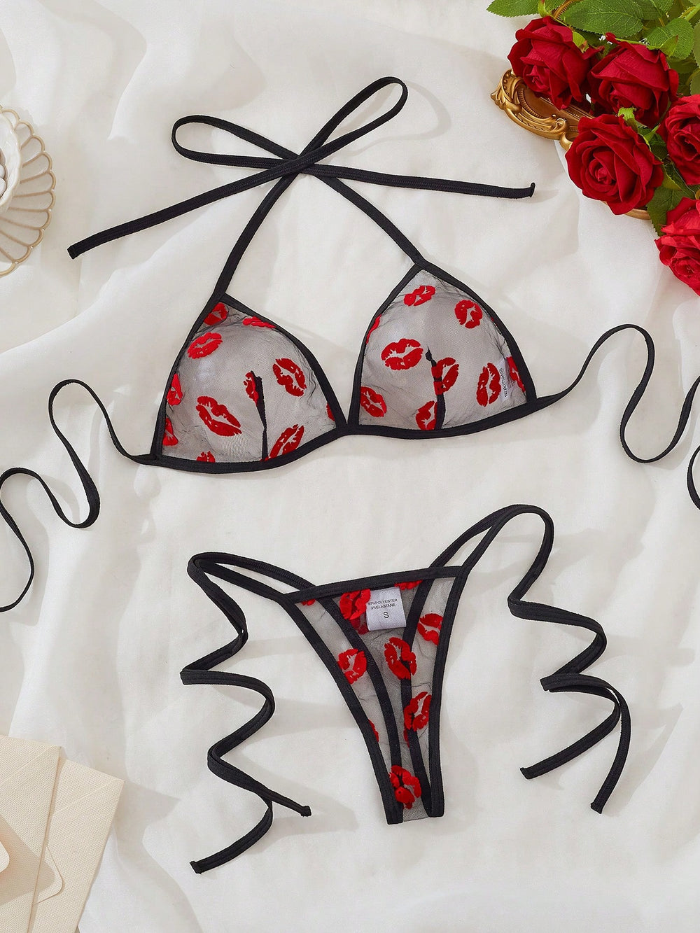 Conjunto de lencería negro transparente con estampado de labios romántico floral vista completa.
