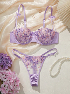 Imagen 1: Conjunto De Lencería Morada con bordado floral presentado sobre tela de seda.