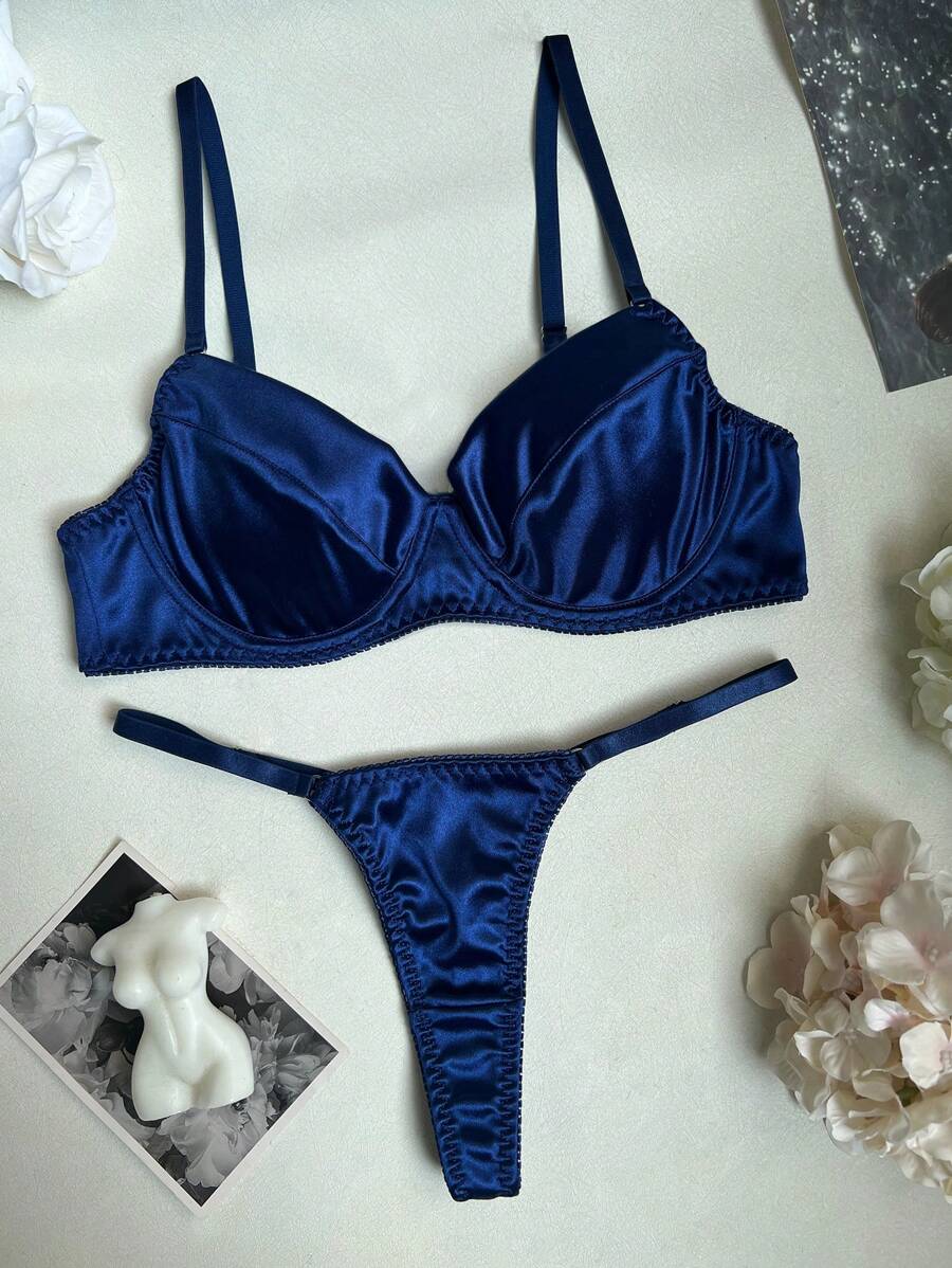 Vista frontal de conjunto de lencería azul zafiro satinado con sujetador de aros y tanga ajustable.