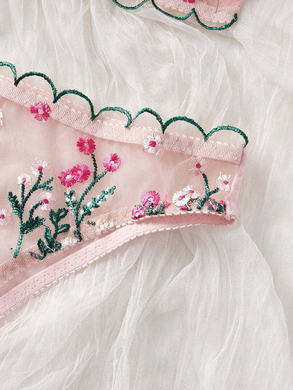 Detalle del bordado floral en el set de lencería rosa.