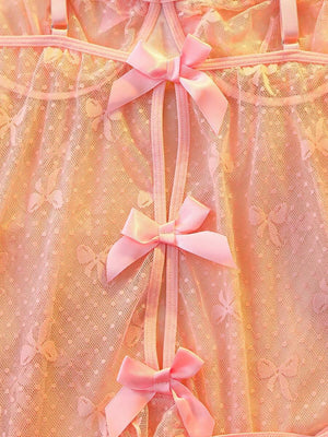 Primer plano del tejido de malla rosa con estampado de mariposas y el borde inferior con volantes.