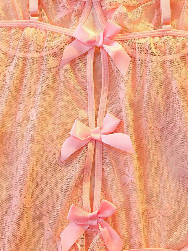 Primer plano del tejido de malla rosa con estampado de mariposas y el borde inferior con volantes.