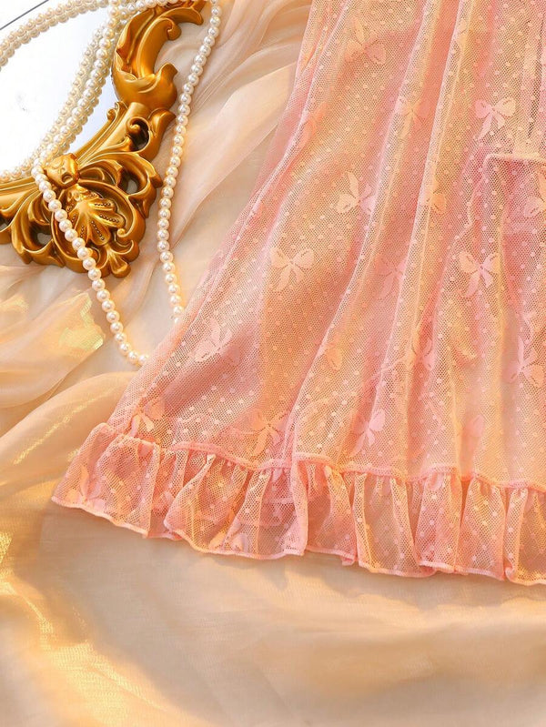 Conjunto de lencería babydoll y tanga rosa mostrando la textura transparente y el diseño romántico.