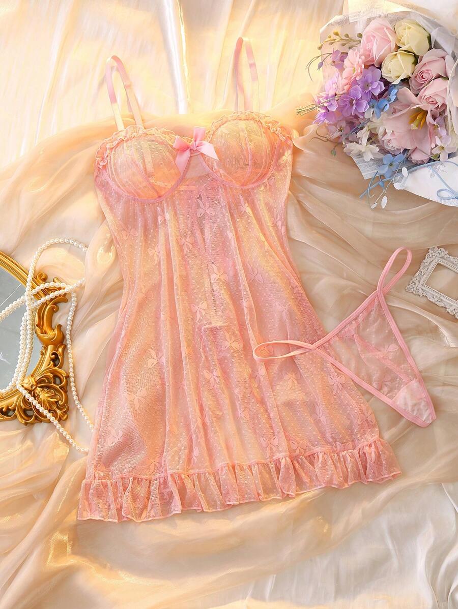 Vista superior de un conjunto de lencería babydoll rosa transparente con tanga a juego sobre una tela satinada.