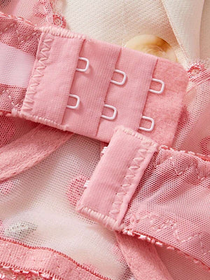 Detalle de tirantes y cierre del set de lencería rosa bordado floral.