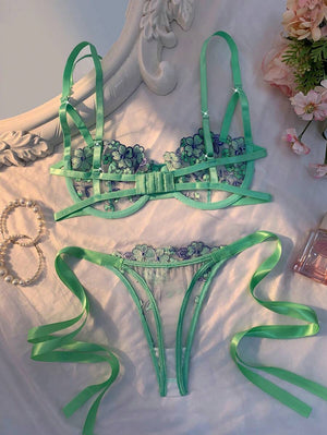 Detalle del sujetador de lencería verde menta con copas de malla transparente y bordado floral.