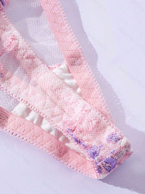 Vista frontal de la tanga a juego con transparencias y bordado floral delicado.