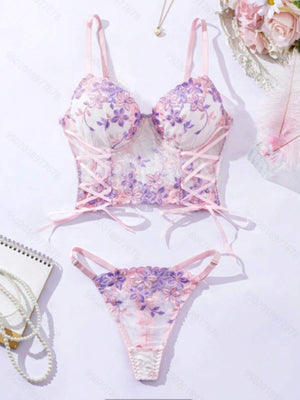 Conjunto de lencería romántico con corset y tanga de bordado floral en tonos rosa y lila.