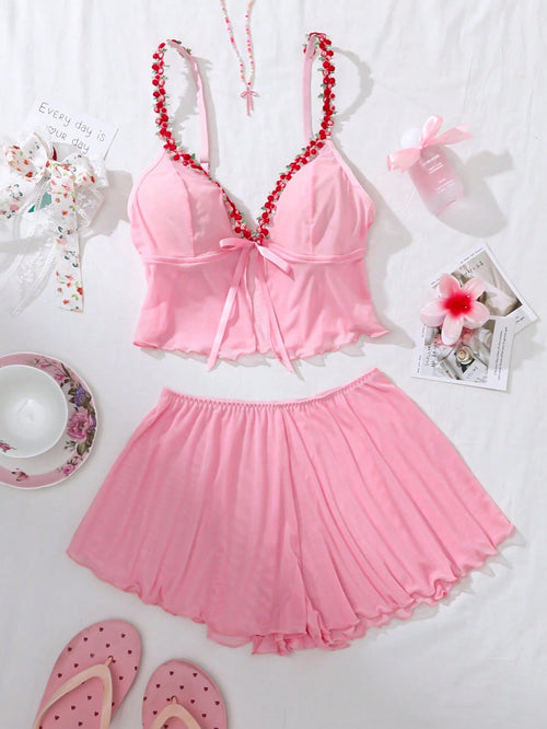 Set de lencería rosa con lazo y volantes visto desde arriba.