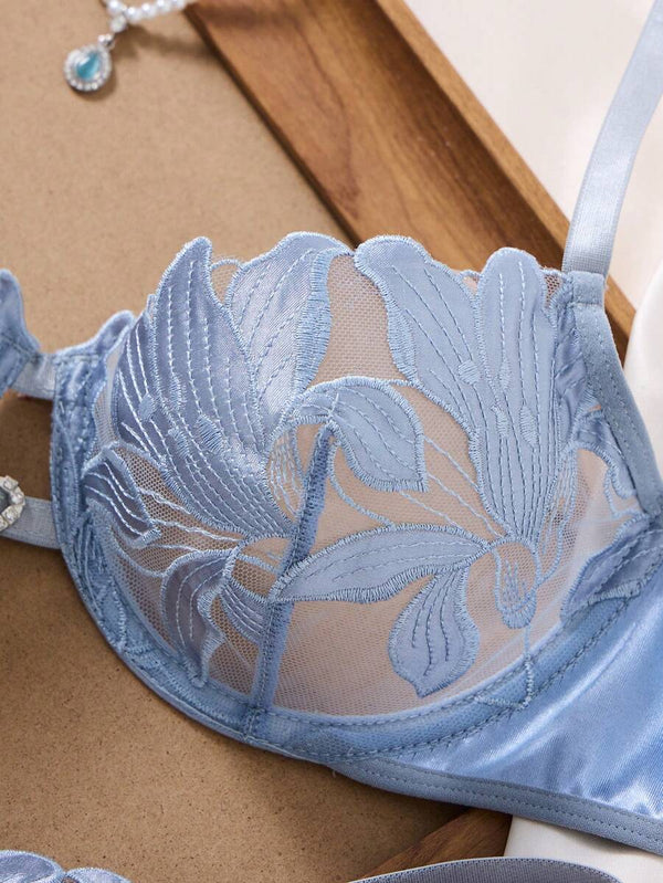 Primer plano de la panti tipo tanga de lencería con bordado floral sobre malla transparente.