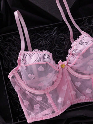 Vista superior del bustier de lencería rosa, mostrando la malla transparente y el diseño de corazones.