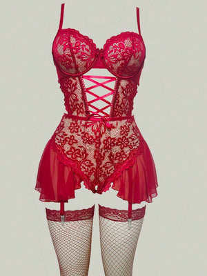 Primer plano del detalle de corset con lazada en la cintura de un body de encaje rojo.