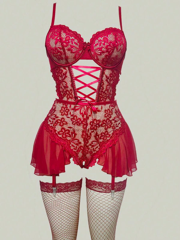 Primer plano del detalle de corset con lazada en la cintura de un body de encaje rojo.