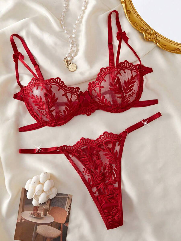 Vista frontal de la tanga de lencería roja a juego, con encaje y bordado floral.