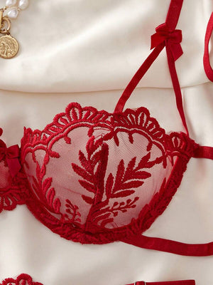 Primer plano del tejido de malla transparente y el detalle del bordado en el sujetador rojo.