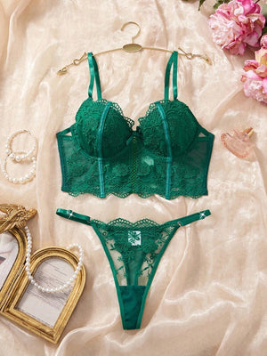 Tanga de lencería verde oscuro con bordado floral y diseño semitransparente.