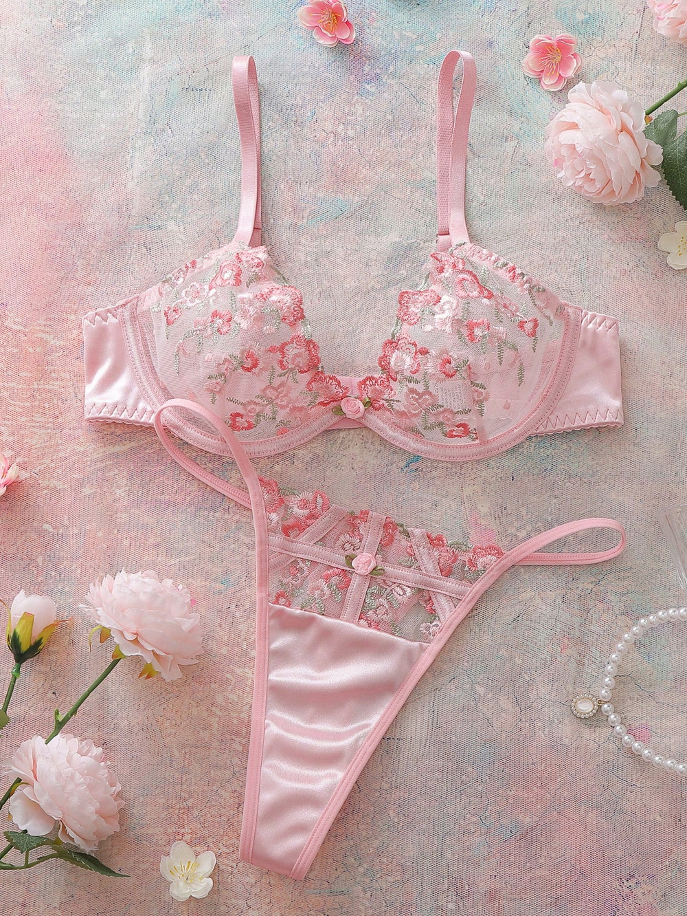Conjunto de lencería romántica rosa con bordado floral vista frontal.
