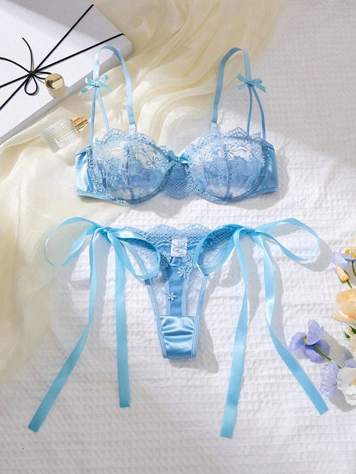 Conjunto de lencería romántico color celeste con encaje floral y lazos de satén, vista completa.