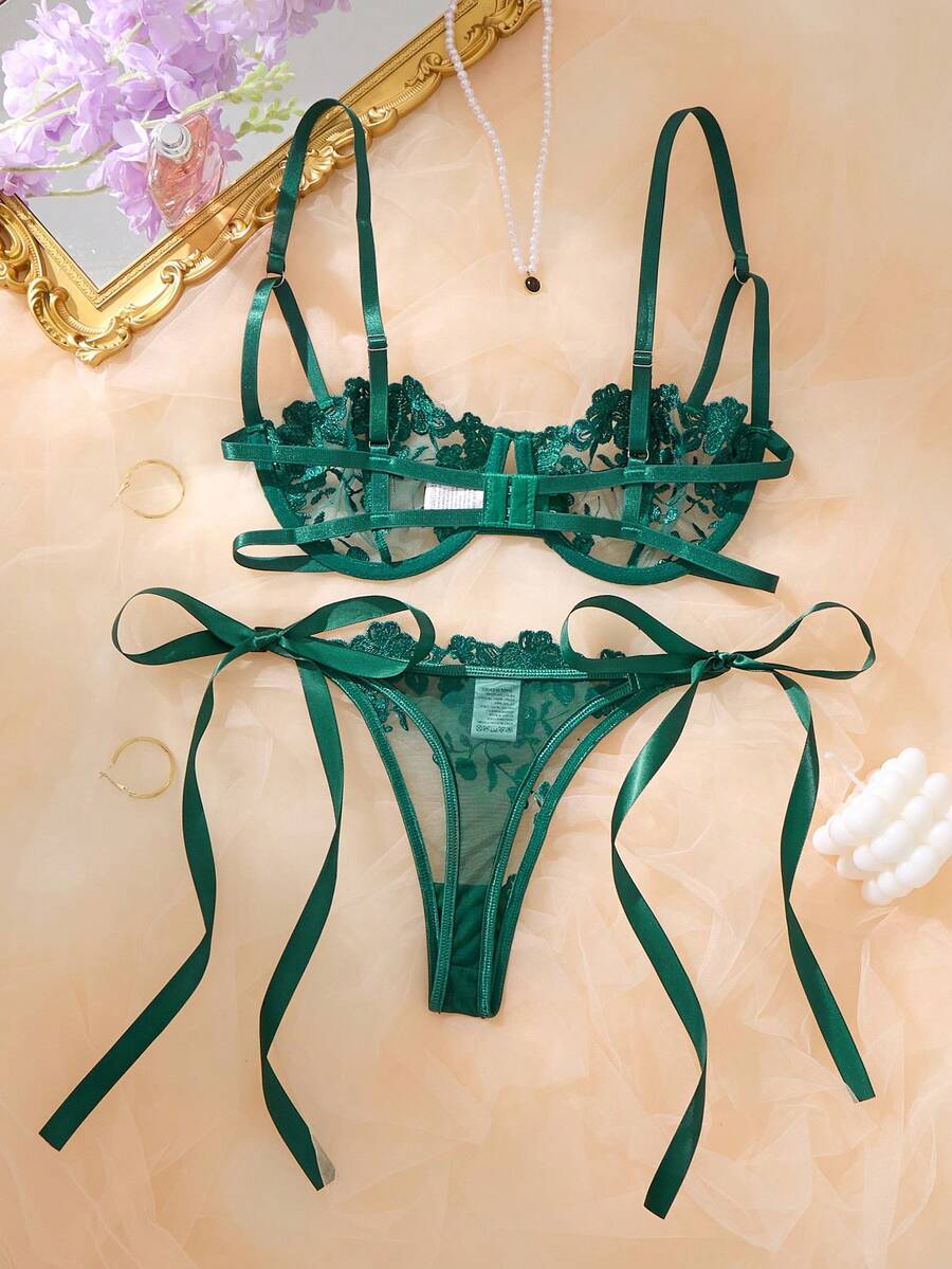 Conjunto de lencería de dos piezas en color verde esmeralda sobre un fondo de seda.