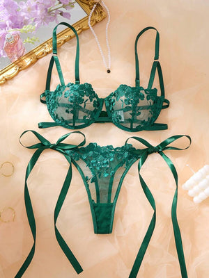 Conjunto de lencería de dos piezas en color verde esmeralda sobre un fondo de seda.