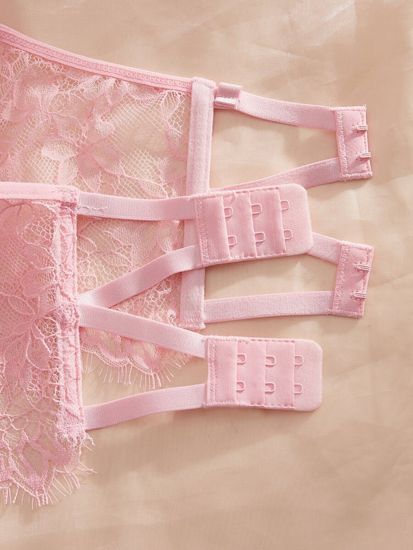 Vista de cerca del tejido de encaje floral rosa y costuras estructuradas del conjunto