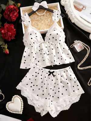 Conjunto de pijama de dos piezas con estampado de lunares sobre fondo blanco y detalles de encaje.