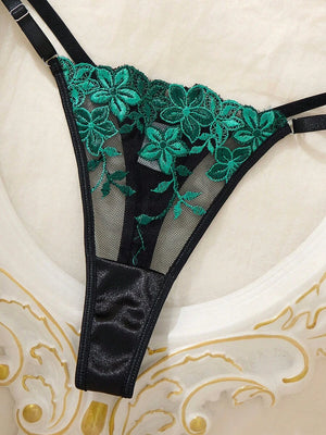 Set de lencería floral verde y negro de dos piezas sobre un fondo decorativo.